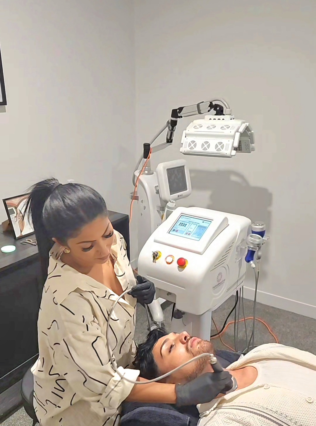 B using the RF handpiece along a client's jawline