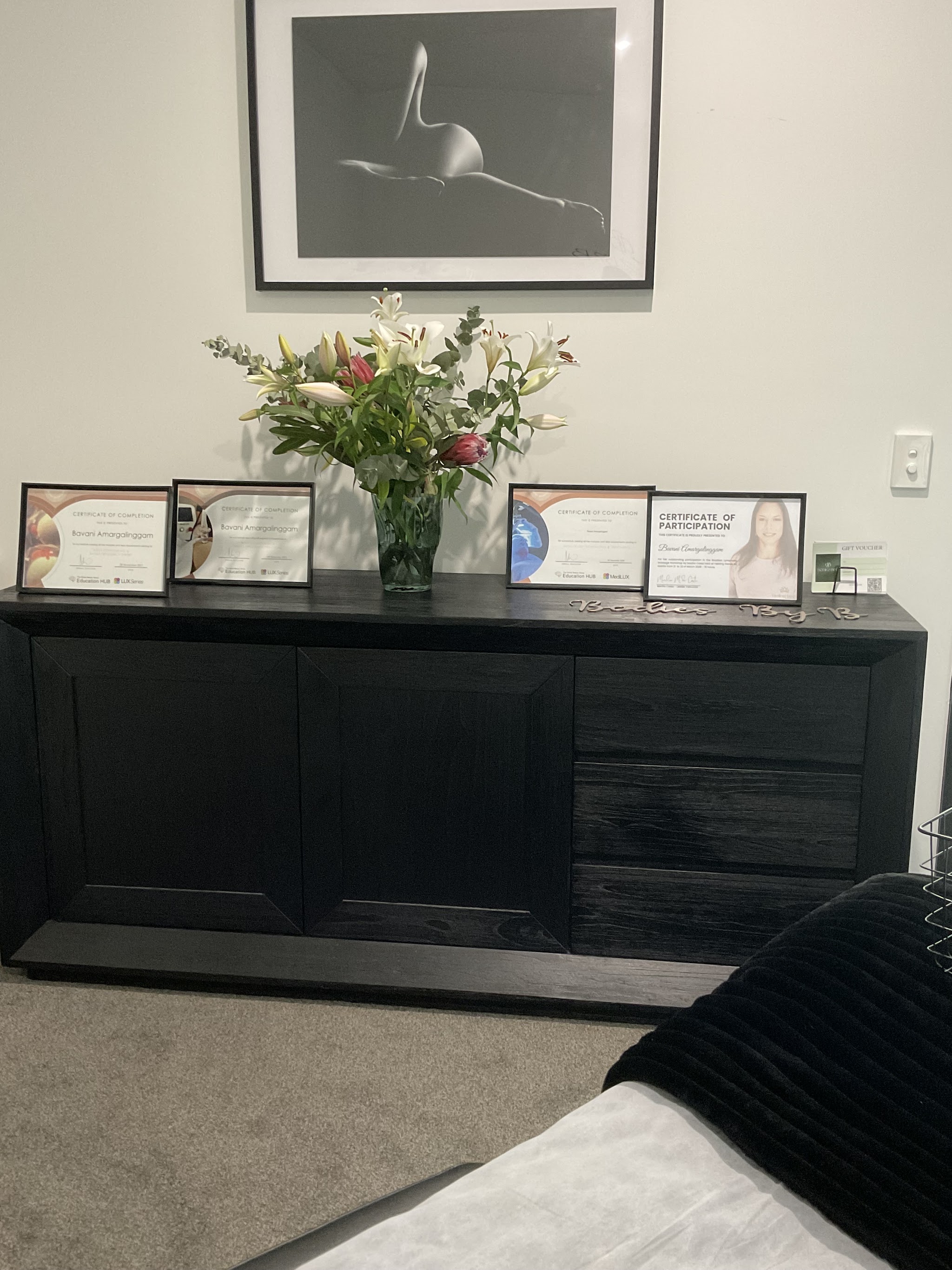 Fresh flowers and framed certificates in the Bodiez By B studio